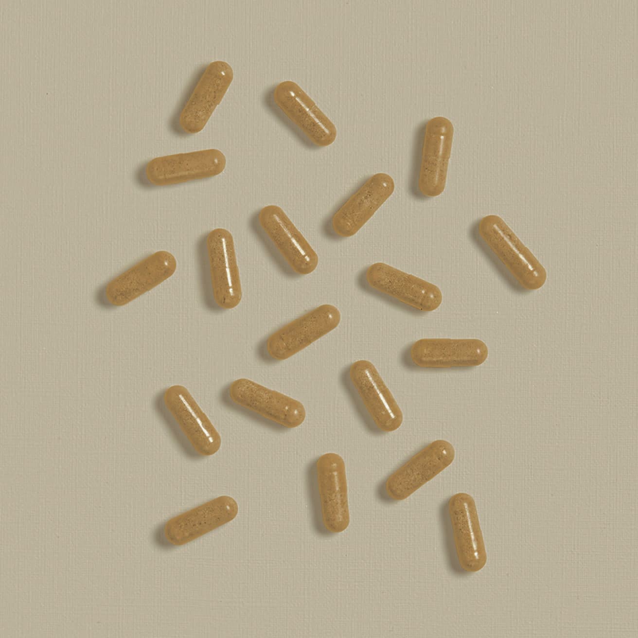 Left: scattered tan capsules on a cream textured surface. (1 of 2)