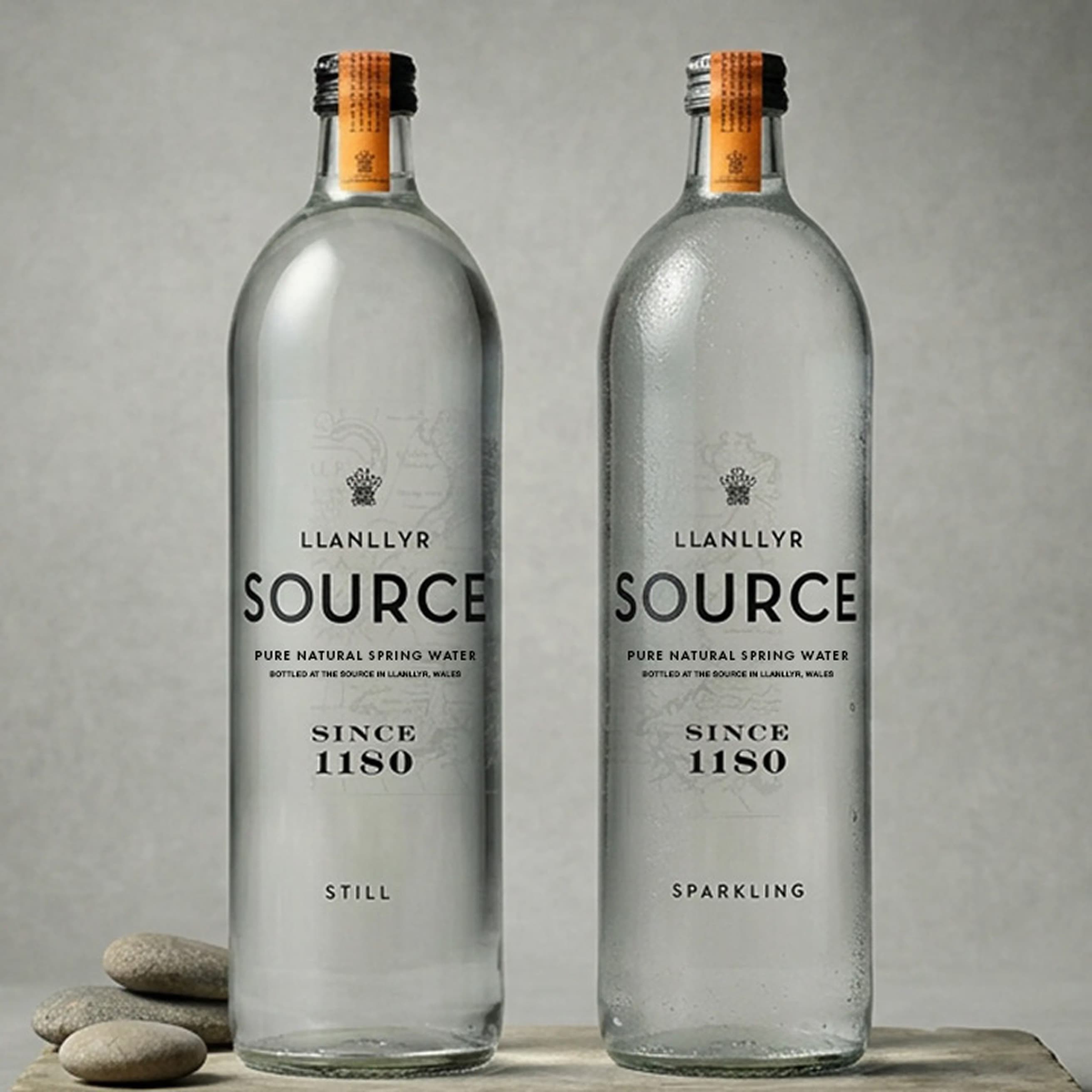 Left: still and sparkling bottles photographed on a pale stone surface with pebbles. (1 of 2)