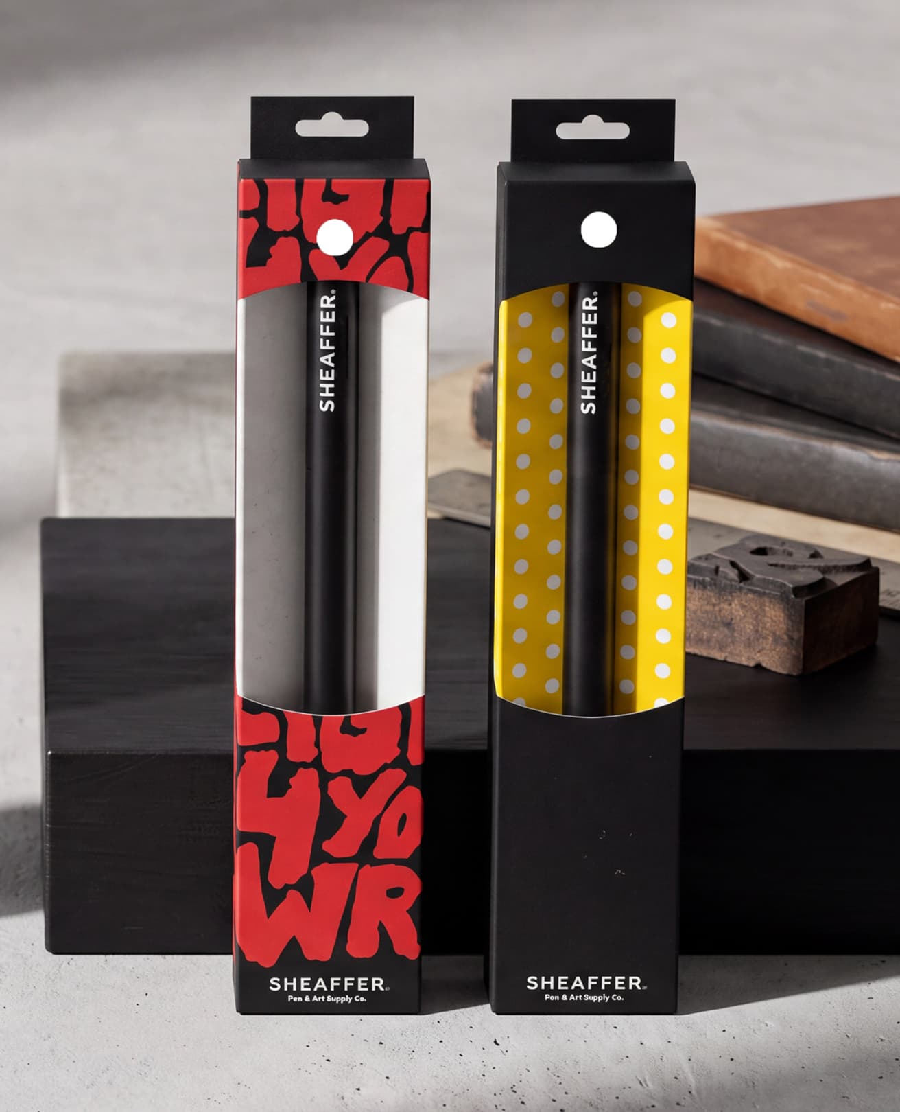 Two Sheaffer pen boxes, one wrapped in red brush lettering, one in yellow polka dots